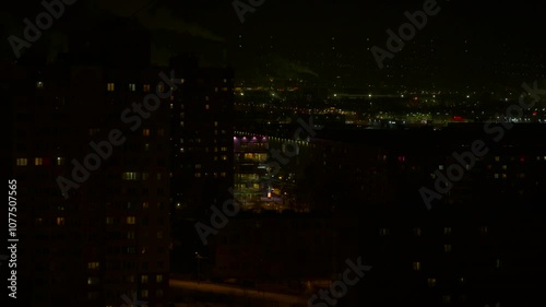 Lonely apartment building during dark night. A view of lonely apartments in lights in the urban place. A view of night city concept. photo