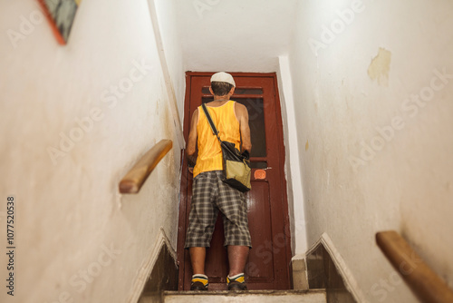 Cuban man at door in narrow staircase photo