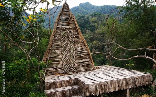 photo of a saung, or simple hut made of wood and with a beautiful thatched roof, in the park photo