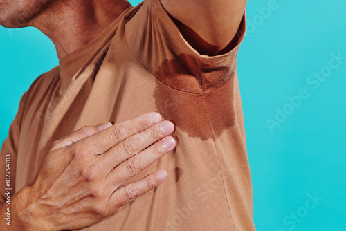 man touching his own sweaty armpit