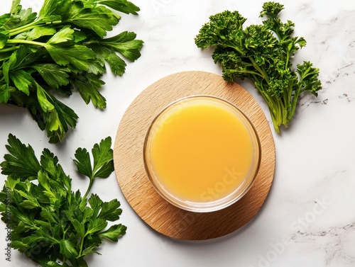 Fresh and Clean Organic Bone Broth in a Glass Bowl Surrounded by Vibrant Green Herbs on a Wooden Surface for Food Editorial Style Photography photo