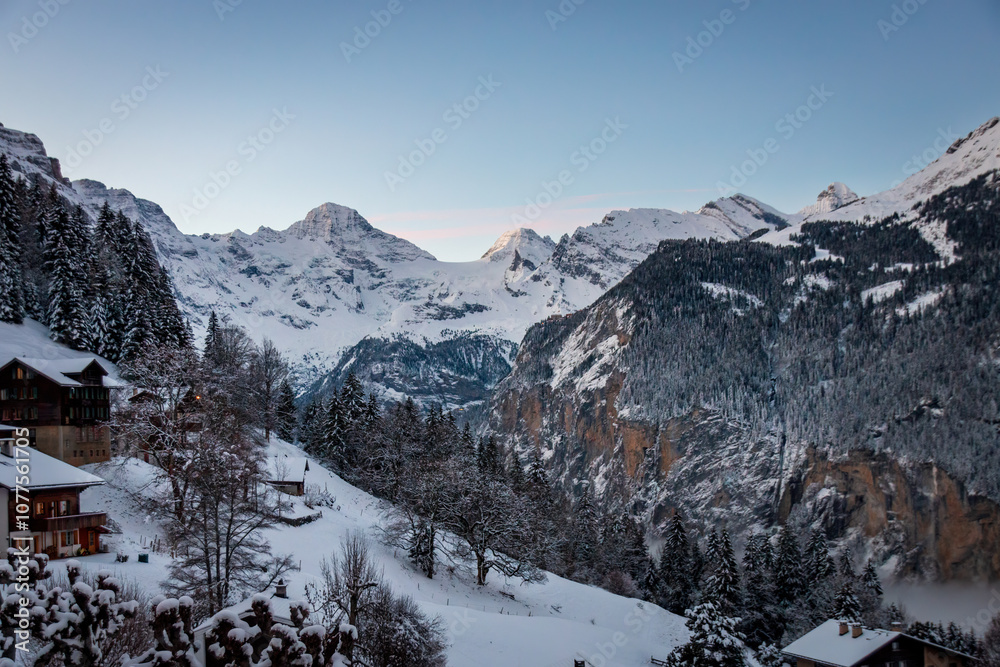 Scenic view of Lauterbrunnen Valley, Switzerland seen from Wengen with snowcovered mountains with Breithorn (left) and Tschingelhorn (right) in winter against blue sky at sunset