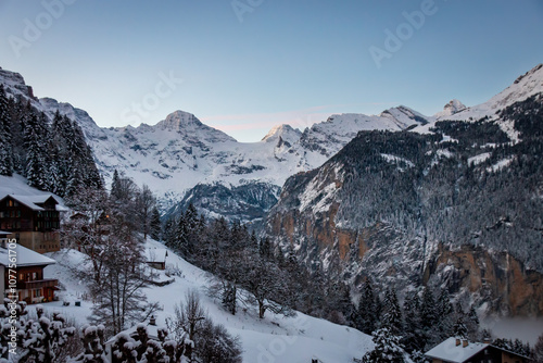 Obraz na płótnie Scenic view of Lauterbrunnen Valley, Switzerland seen from Wengen with snowcovered mountains with Breithorn (left) and Tschingelhorn (right) in winter against blue sky at sunset w salonie