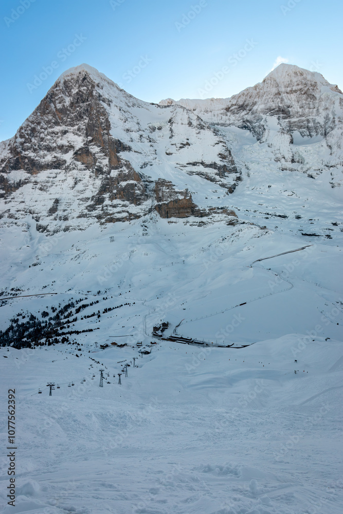 Scenic view of snowcovered Eiger and Mönch mountains in Switzerland early in the morning against blue sky