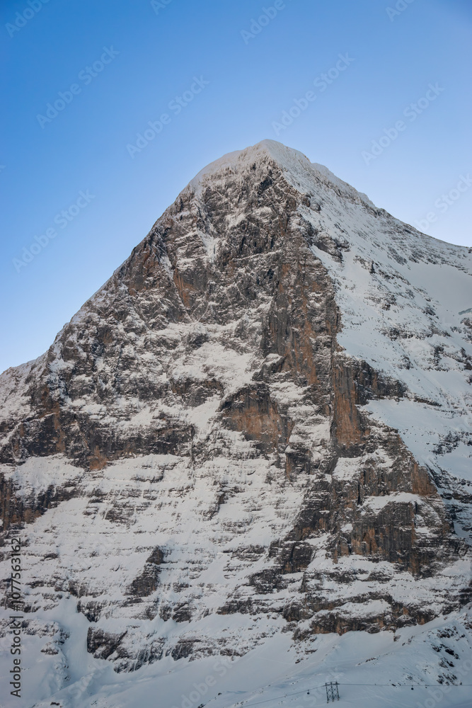 Scenic view of snowcovered Eiger mountain in Switzerland in winter early in the morning against blue sky