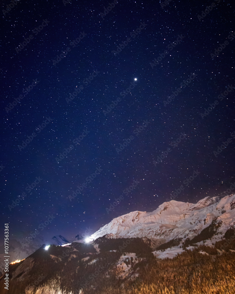Scenic view of snowcovered mountains near Lauterbrunn at night under sky full of stars in winter