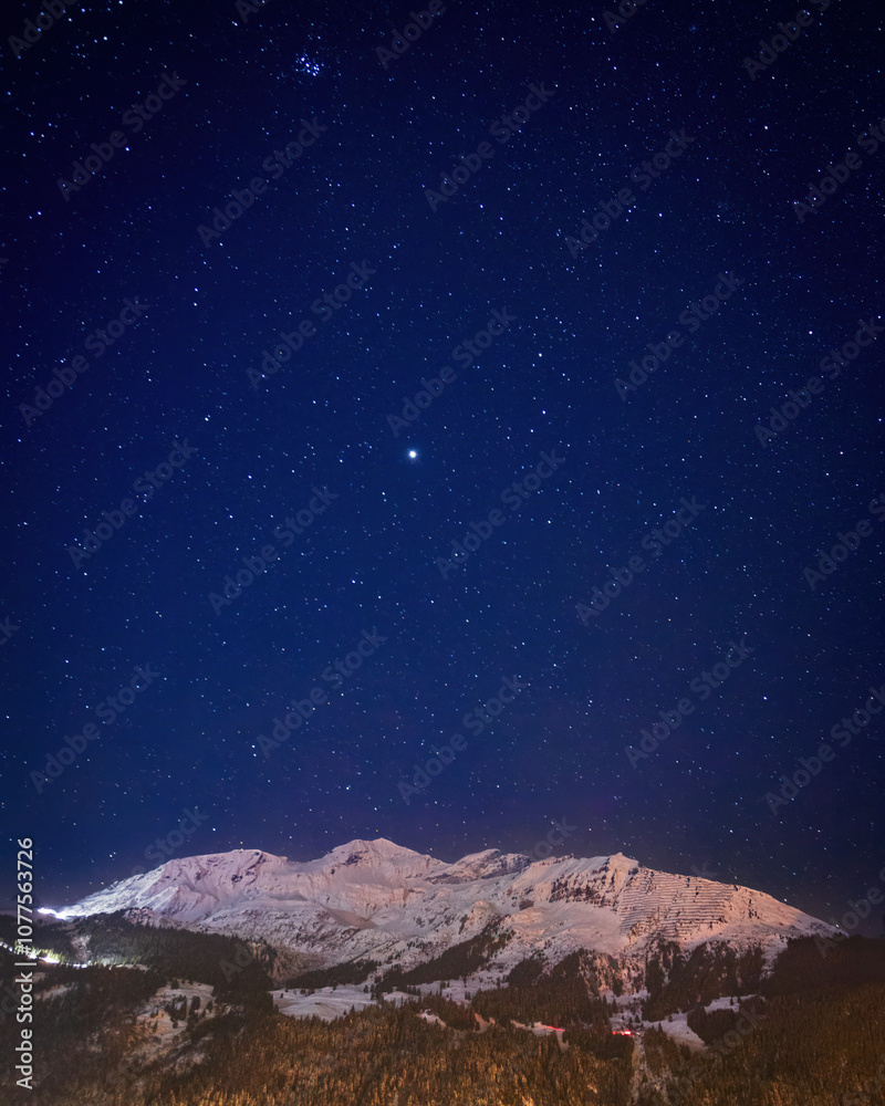 Scenic view of snowcovered mountains near Lauterbrunn at night under sky full of stars in winter