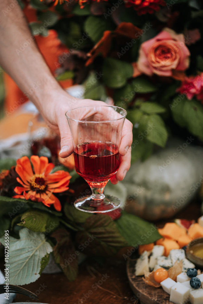 Elegant Hand With Drink in Floral Setting