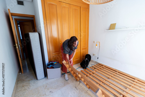 Woman cleaning furniture in empty room with dog before moving out photo