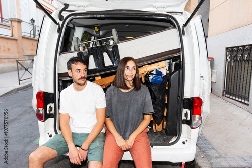 Young couple resting in moving van trunk