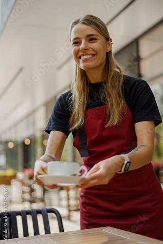 In a lively outdoor cafe, a cheerful waitress is happily serving steaming hot coffee, fostering a warm ambiance