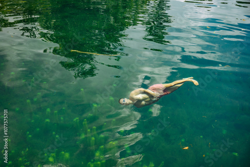 Man Relaxing Underwater in Clear Green Lagoon photo