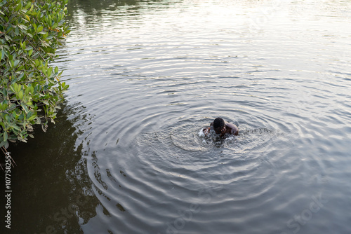 Young man swimming in a river in senegal photo