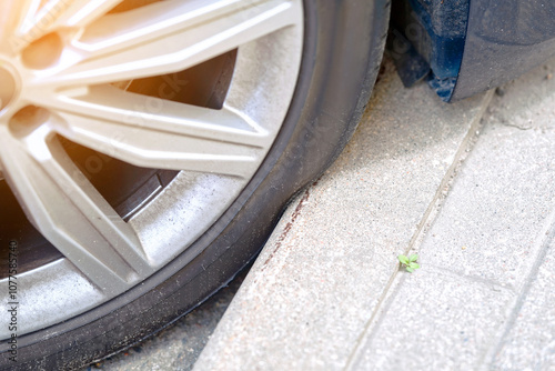 Konstfotografi Car tire pressed against curb risk of internal damage from hitting curb, potential tire blowouts