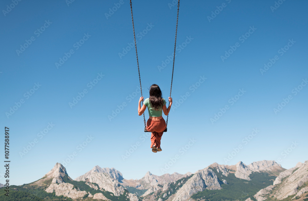 Swinging woman enjoying peaceful mountain view