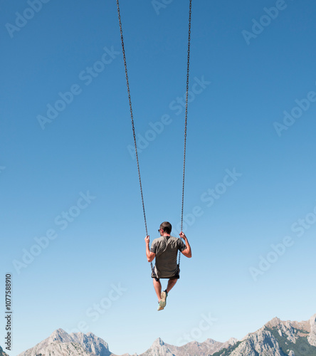 Relaxed man on big mountain swing photo