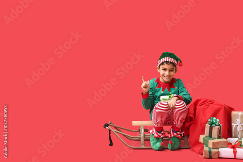 Cute little elf with sled a...