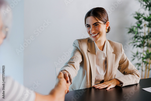 Financial advisor shaking hands with client at office