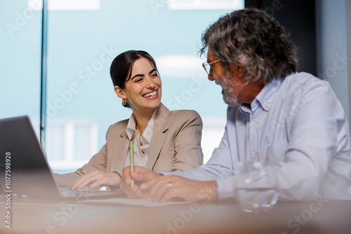 Business people working on laptop in meeting room