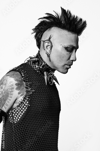 Punk aesthetic man with spiky hair and piercings in black and white photo