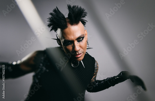 Edgy punk man with mohawk and spikes in futuristic fashion photo