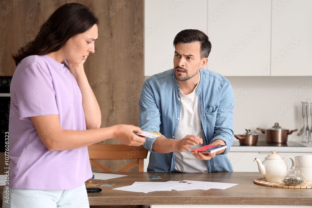 Desperate woman giving credit cards to her husband at home. Bankruptcy concept Desperate woman giving credit cards to her husband at home. Bankruptcy concept