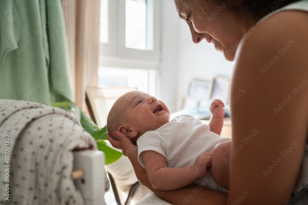 Smiling baby looking at mother holding him at home Smiling baby looking at mother holding him at home