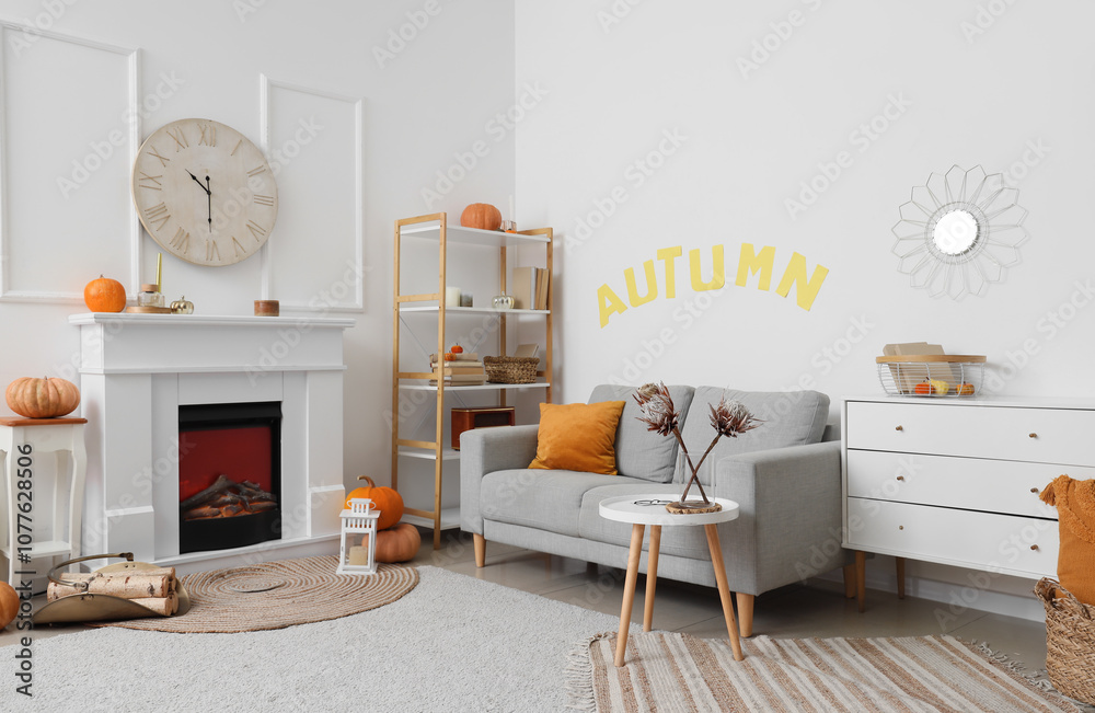 Naklejka premium Interior of light living room with white fireplace, coffee table, cozy sofa and clock