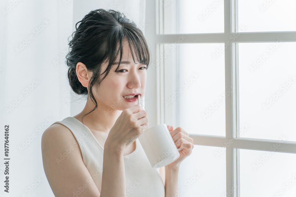 歯磨き中に奥歯が痛くなるアジア人女性
歯磨き中に奥歯が痛くなるアジア人女性