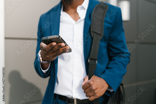 Anonymous Man Holding Smartphone with Shoulder Bag photo