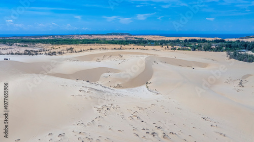 Aerial view of Bau Trang lake (a beautiful landscape, raw of automobiles with blue sky in desert, beautiful landscape of white sand dunes), the popular tourist attraction place in Mui Ne, Vietnam.