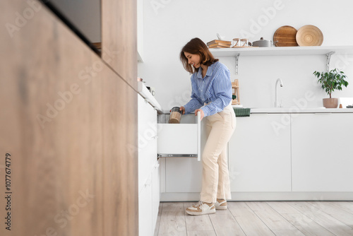 Young woman taking jar of p...