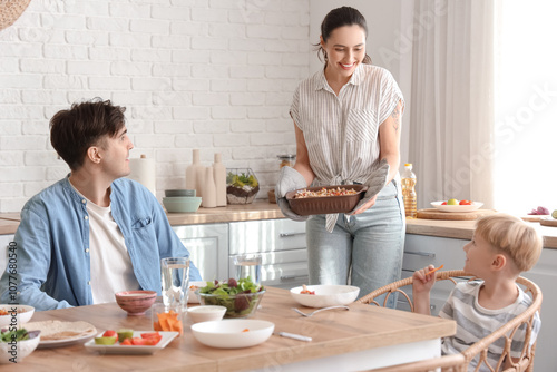 Fotografia Young woman bringing Fajita to her family at dinner in kitchen