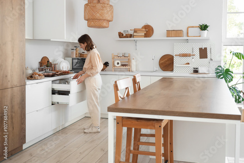 Young woman taking ladle fr...