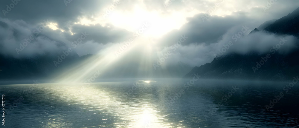 Dramatic sunbeams breaking through clouds over a misty lake.