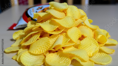 A pile of potato chips on a table, perfect for snacking or movie night photo