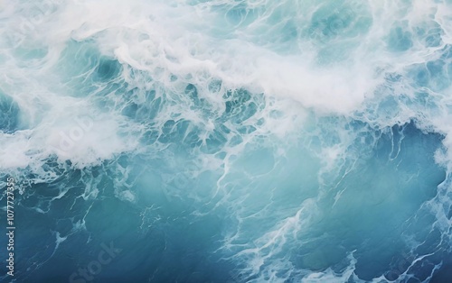 Aerial view of swirling ocean waves in varying shades of blue and white foam.