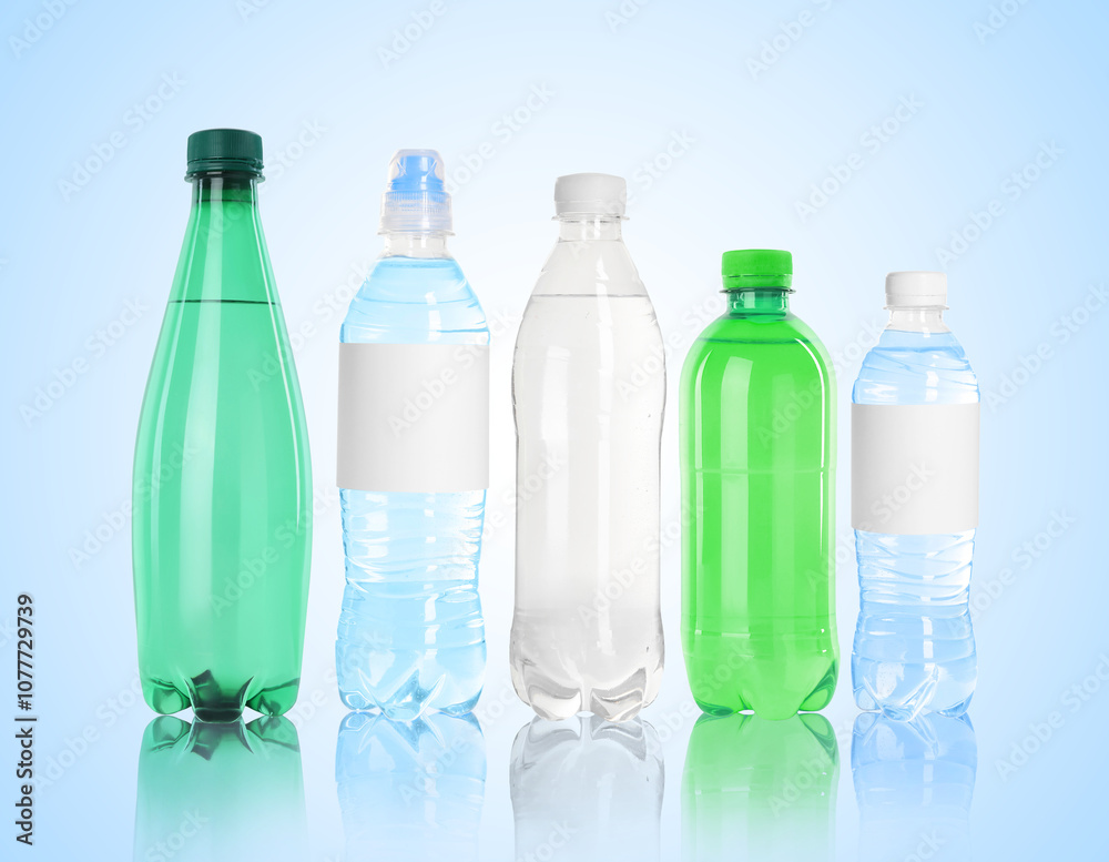 Different plastic bottles with water on light blue background Different plastic bottles with water on light blue background