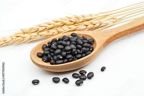 Black beans in wooden spoon with ear of wheat  photo