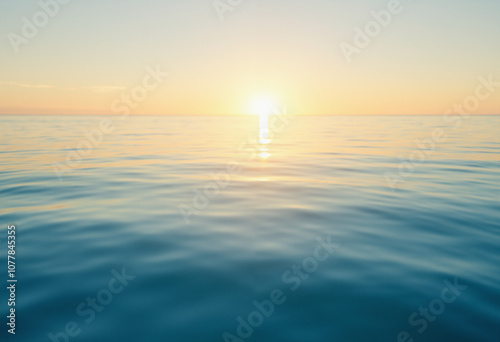 Calm ocean at sunrise with soft ripples and golden light