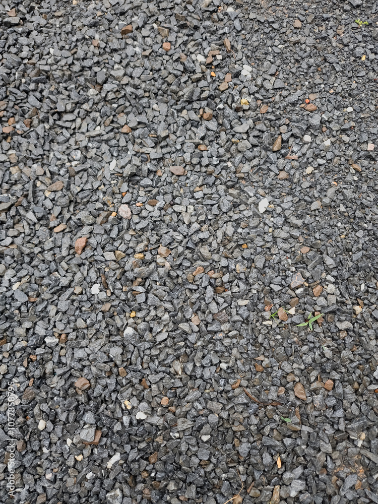 Gray small rocks ground texture. black small road stone background. gravel pebbles stone seamless texture. dark background of crushed granite gravel, close up. Gray small rocks ground texture. black small road stone background. gravel pebbles stone seamless texture. dark background of crushed granite gravel, close up.