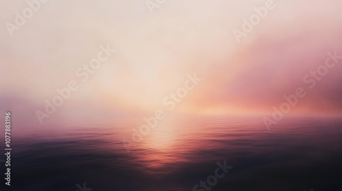 A soft, blurred sunset over a calm body of water. The sky is filled with a soft, pink and orange glow.