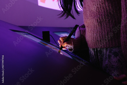 Woman drawing on interactive touchscreen with a stylus in a museum