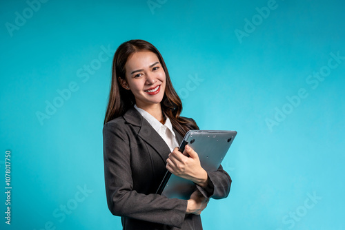 Portrait of Asian businesswoman standing in isolated blue background. 