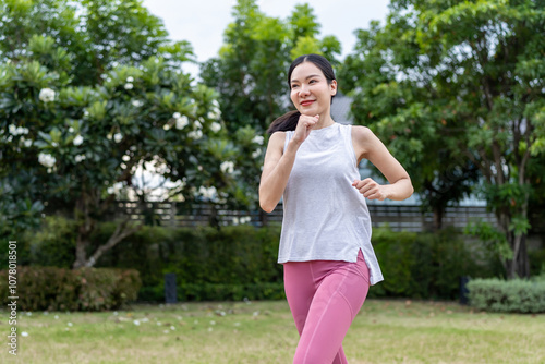 Asian beautiful sportswoman doing running exercise alone in the garden. 