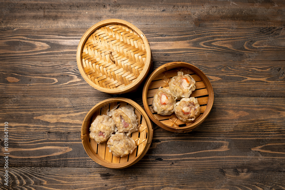 Assorted chinese dim sum dumpling on bamboo wooden basket bowl on wooden table Assorted chinese dim sum dumpling on bamboo wooden basket bowl on wooden table