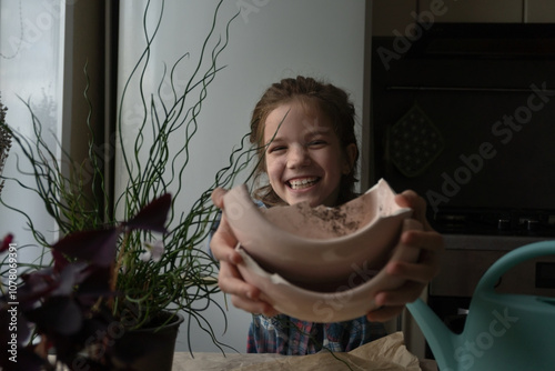 A girl transplants a houseplant into a ceramic pot. Home gardening, biophilia and greenery concept. photo