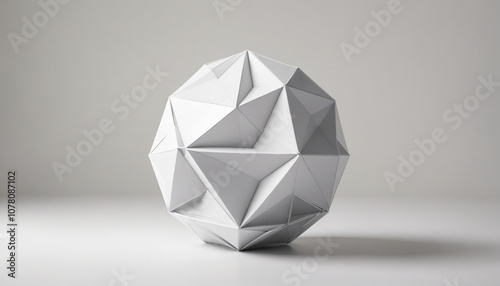 A white, geometric sphere sits on a plain surface against a light gray background