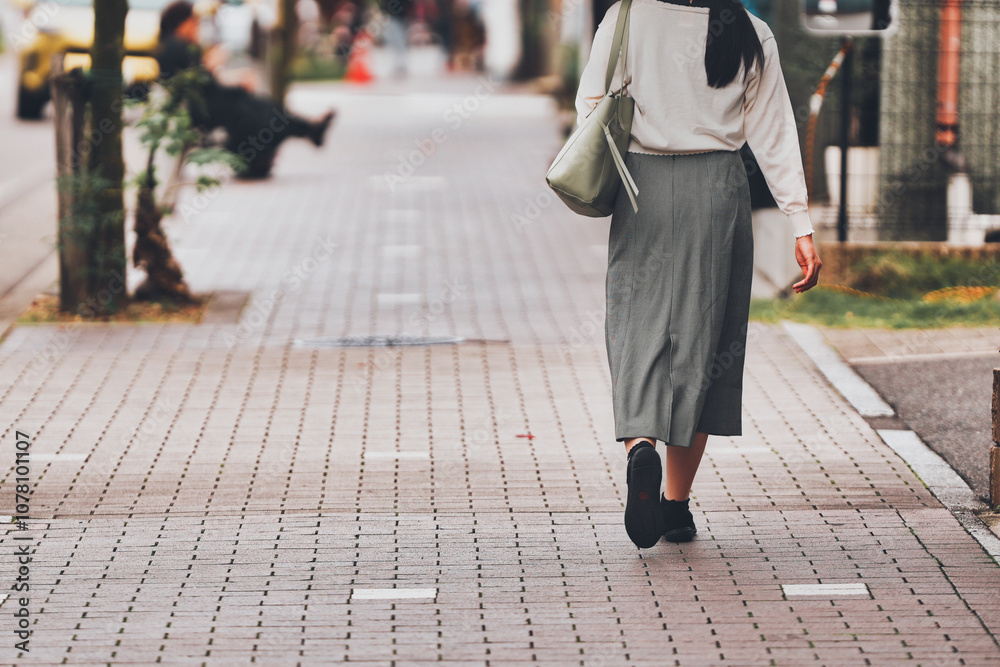 Fototapeta premium 都市を歩く女性の後ろ姿