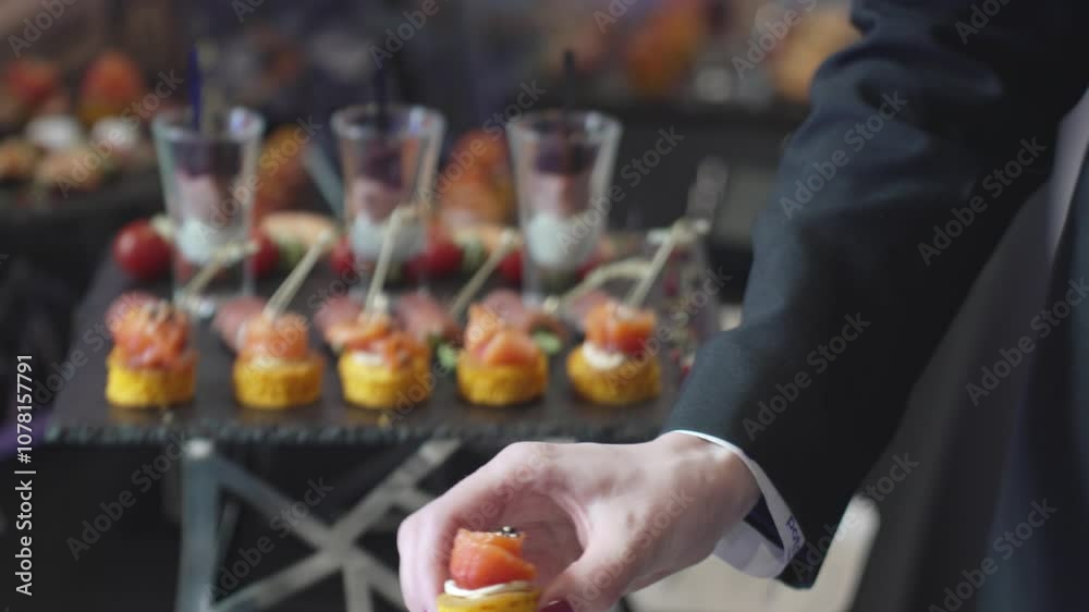A man takes appetizers on a buffet table A man takes appetizers on a buffet table
